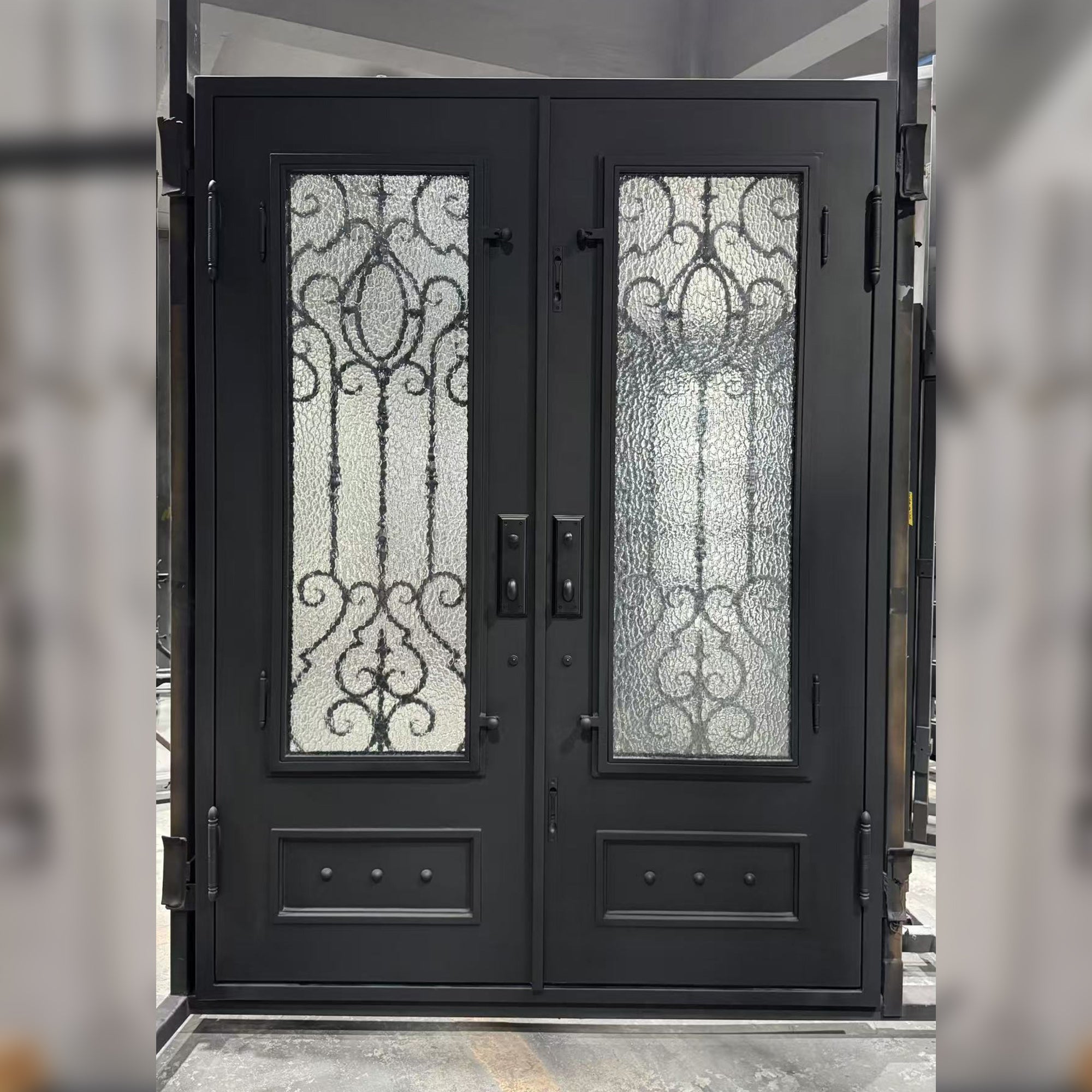 Black double door with decorative glass panels in a showroom setting