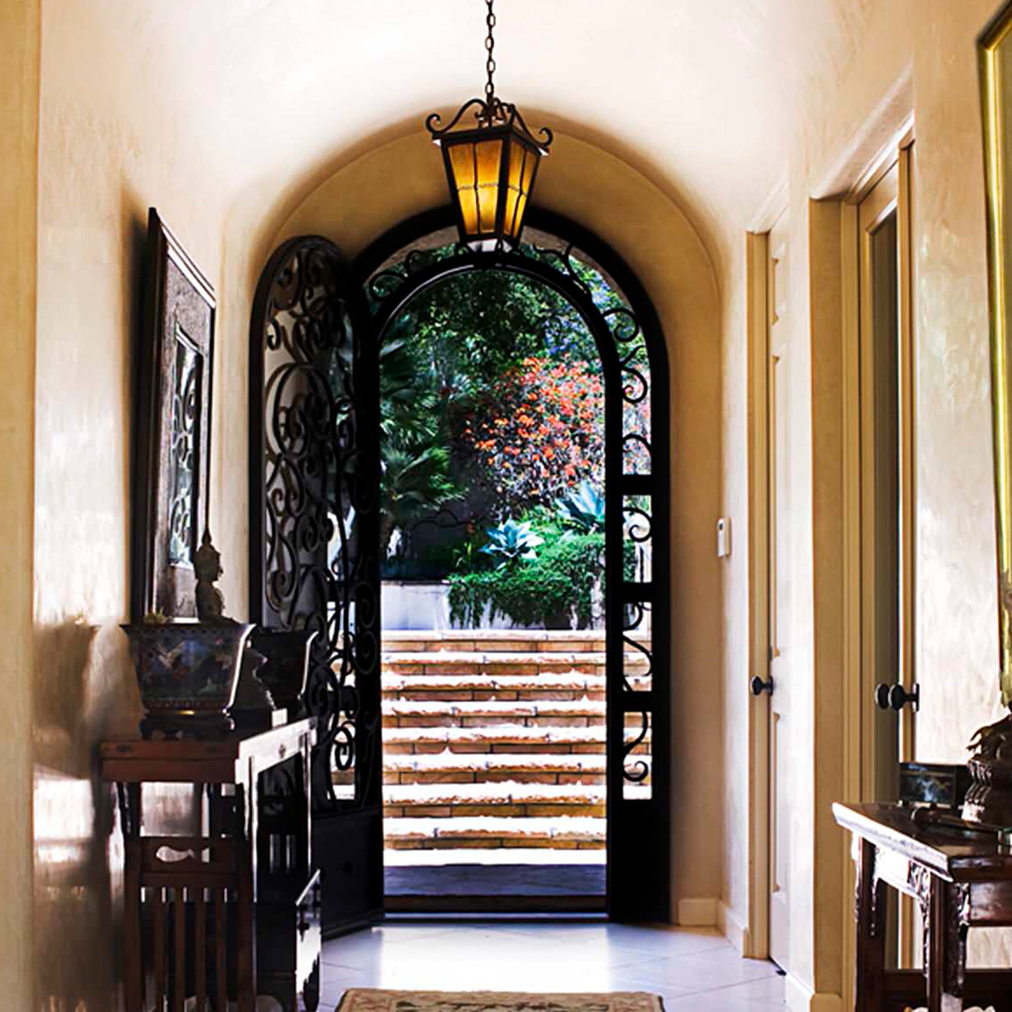 gid arched top iron entry door with delicate scrollwork
