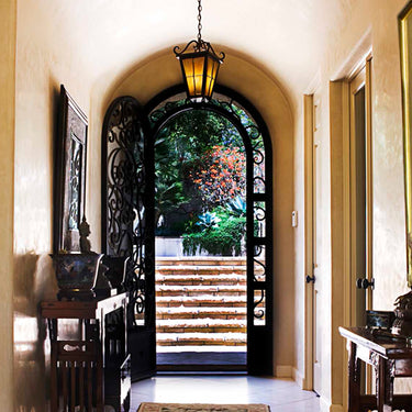 gid arched top iron entry door with delicate scrollwork