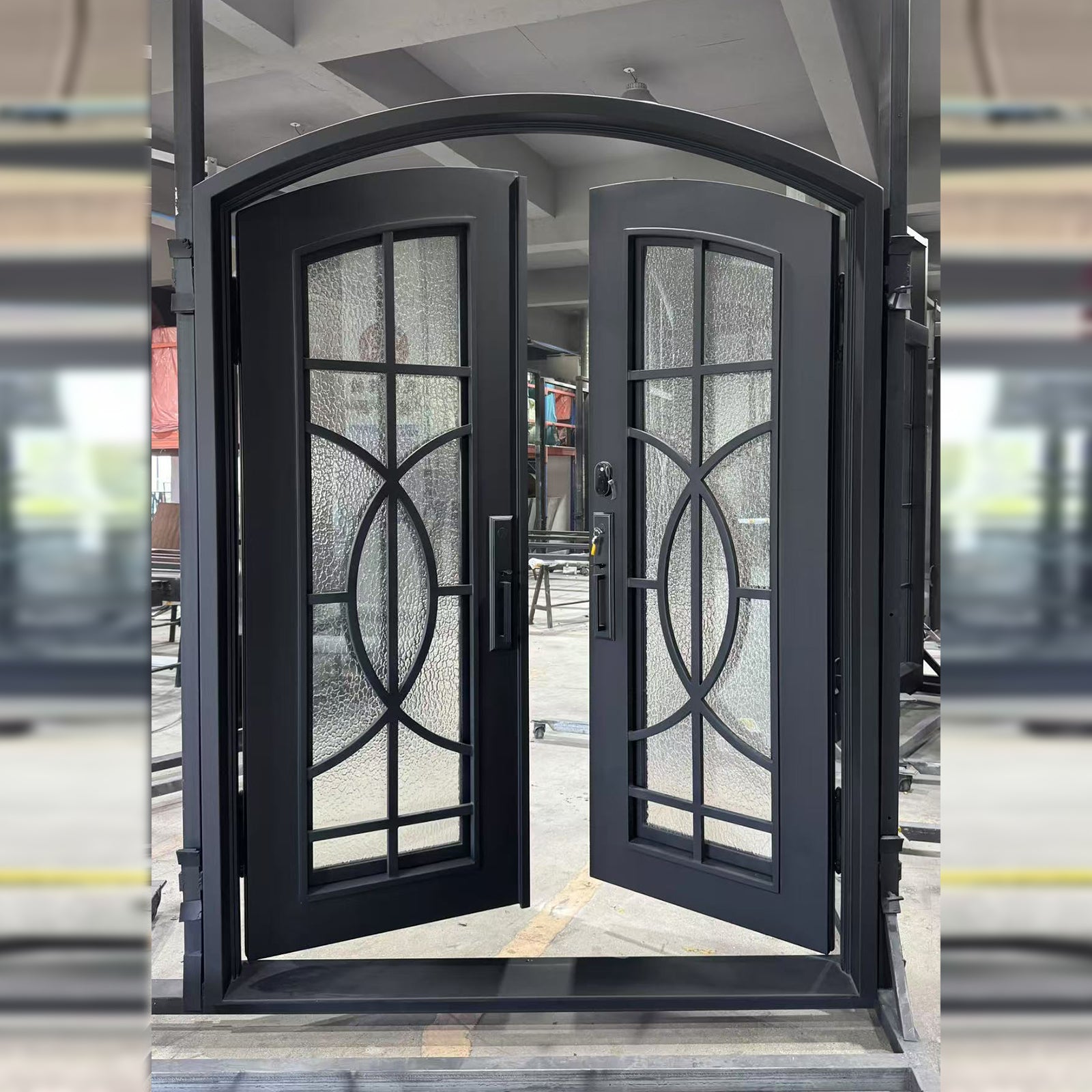 Black wrought iron double door with decorative glass panels in an indoor setting.