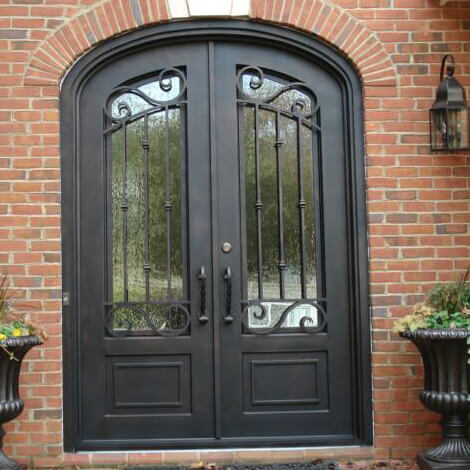 oil rubbed bronze finish arched top iron double entry door with simple scrollwork and kickplate