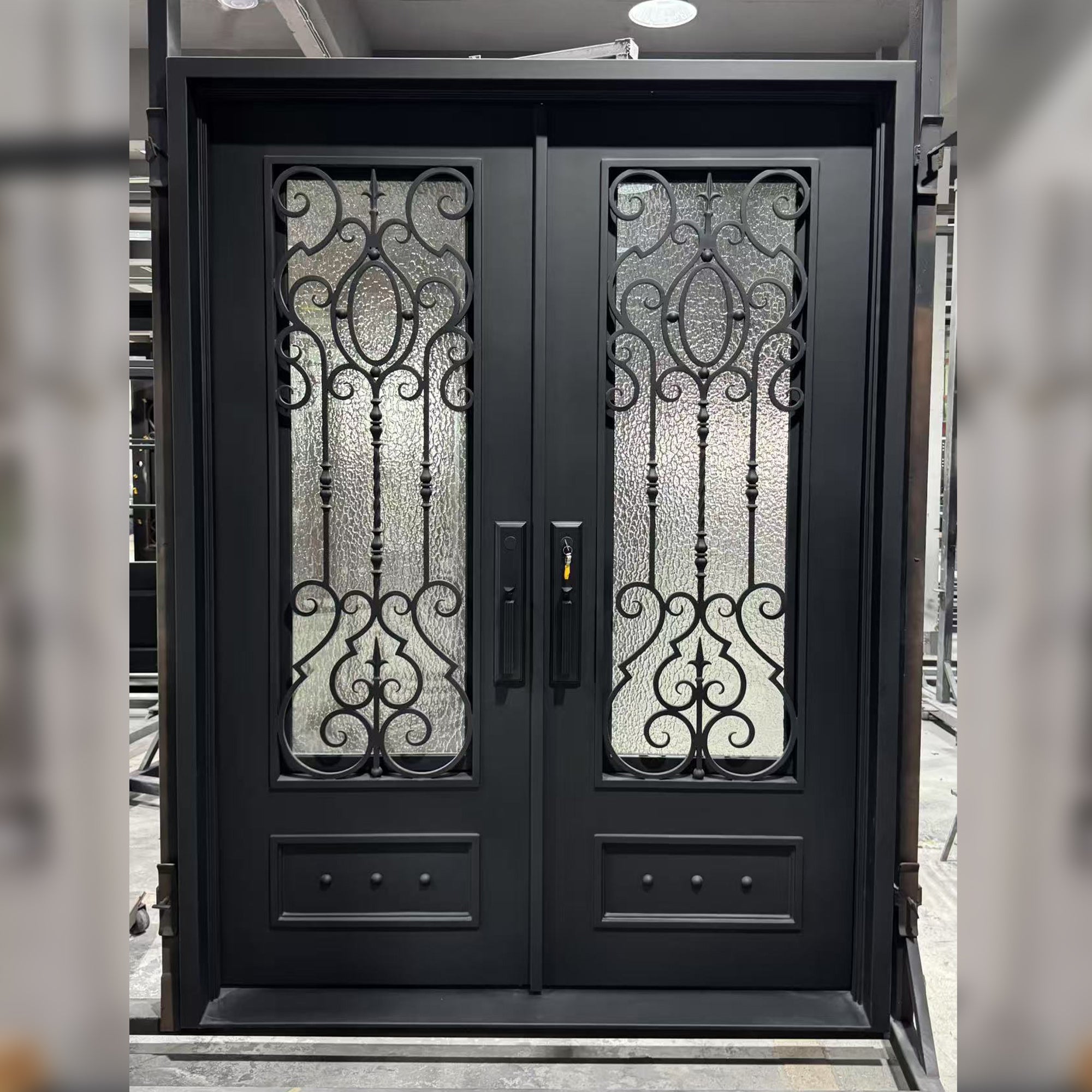 durable iron door with a sleek, matte black finish, featuring intricate scrollwork design