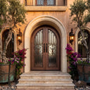 Mediterranean style arched iron front door with scrollwork
