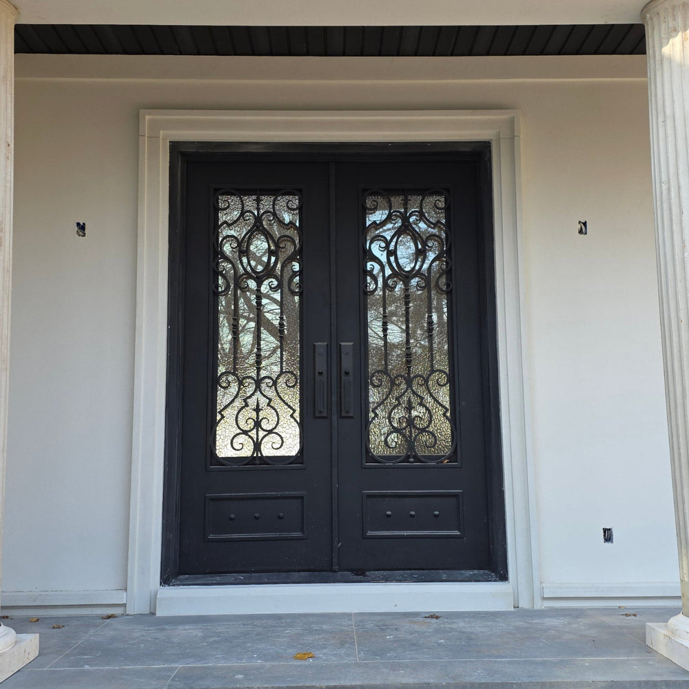 Front door of a house with decorative columns and a black door.