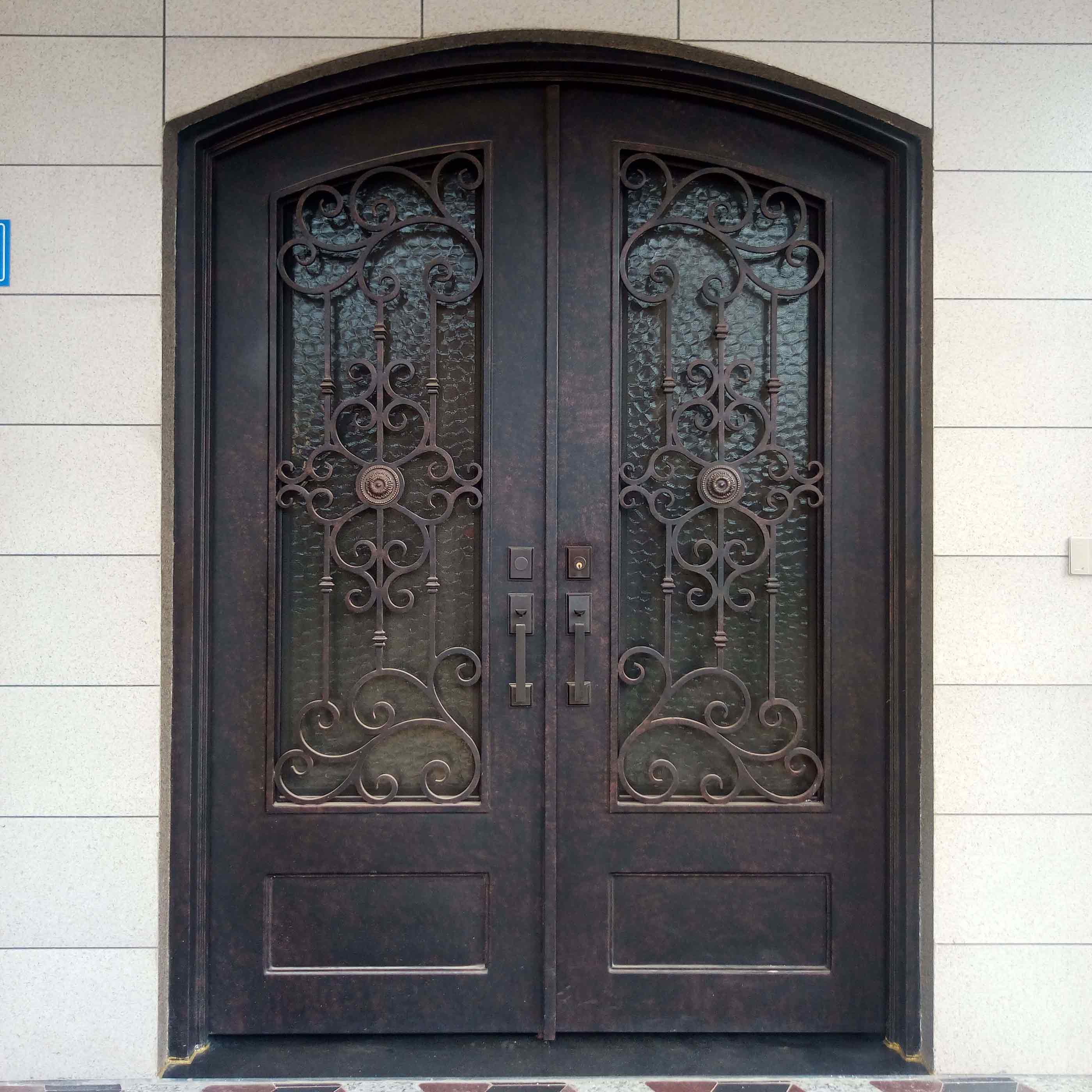 aged bronze wrought iron double door with eyebrow arched top