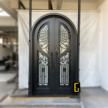Decorative black metal door with intricate designs and round top
