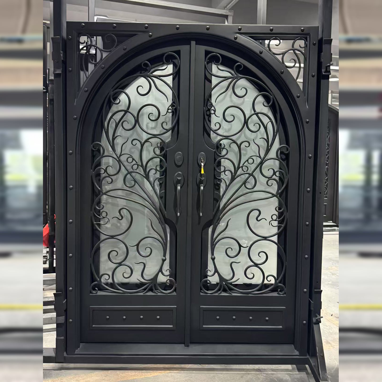 Decorative black wrought iron double door with intricate designs on a blurred background