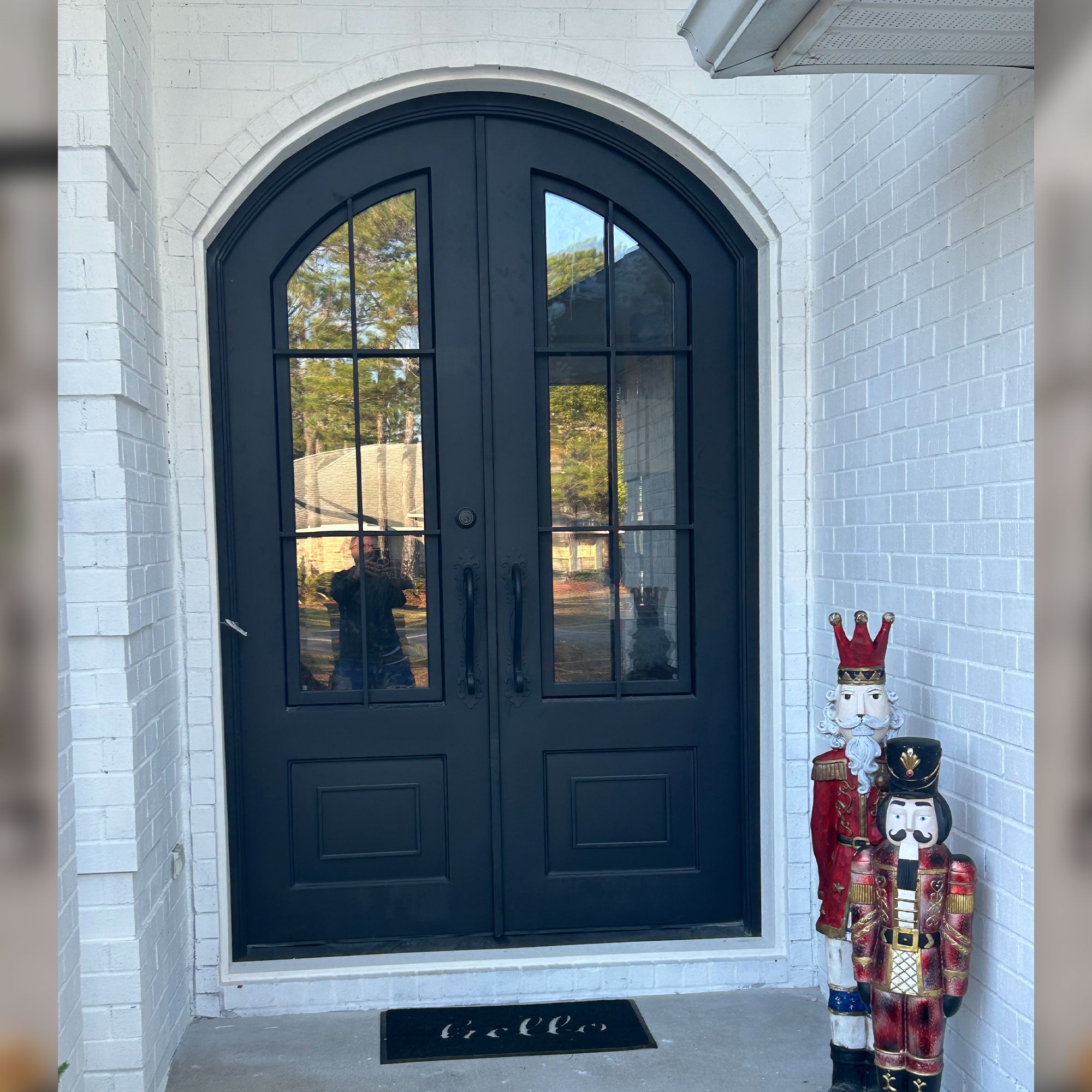 Black iron double door entrance with arched top