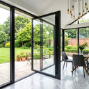 Modern clear glass pivot door opening to a backyard garden