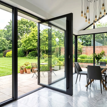 Modern clear glass pivot door opening to a backyard garden