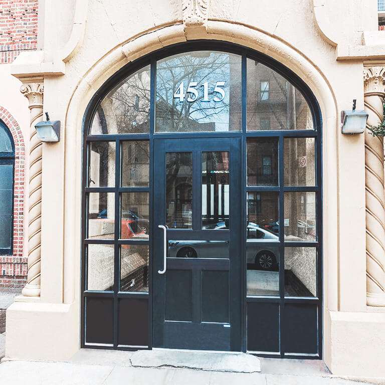 Single iron front door with round transom and kickplate